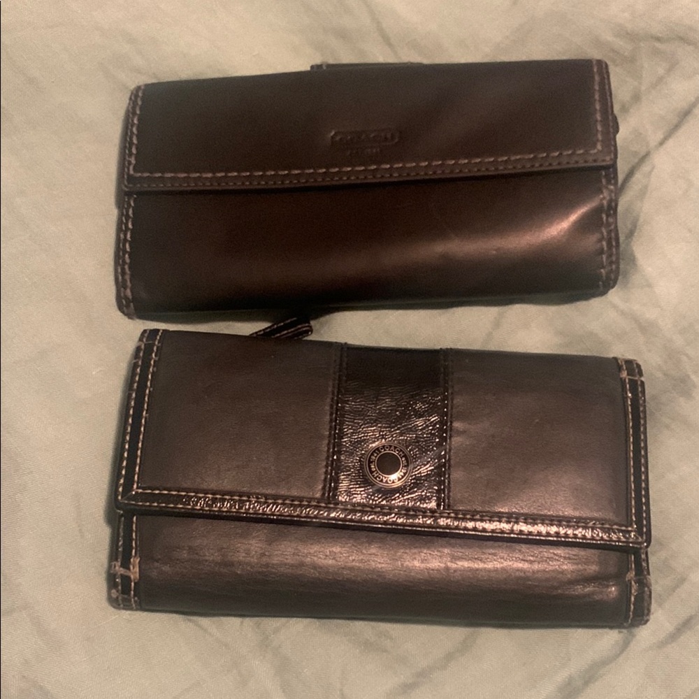 2  Black Coach leather wallets one with checkbook. Both wallets have some peel
